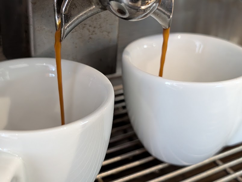 Espresso z kávy zo slovenskej pražiarne sa naleje do dvoch šálok v Coffee Time Vrakuňa