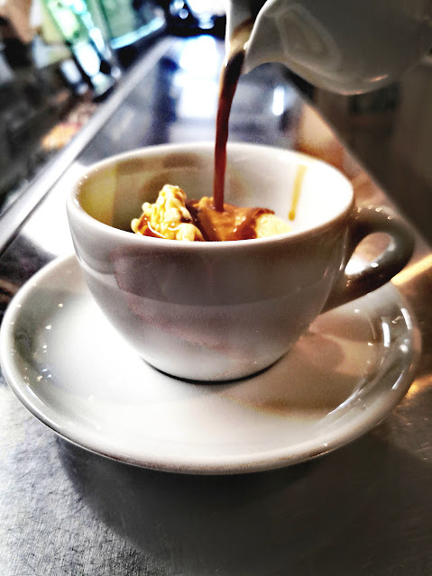 Príprava kávy so šľahačkou a karamelom v šálke na bare Coffee Time Vrakuňa
